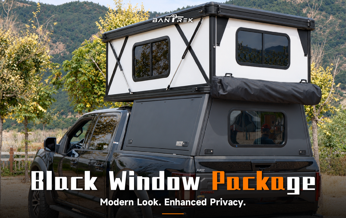 BANTREK camper with black window package installed on black pickup truck in outdoor setting