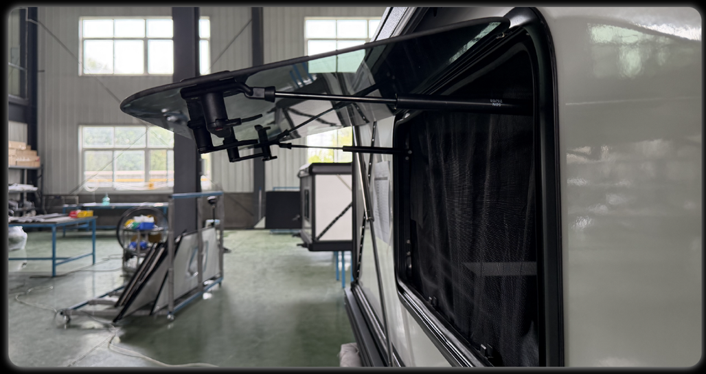 RV exit window open from interior showing gas strut support and mesh screen in factory setting