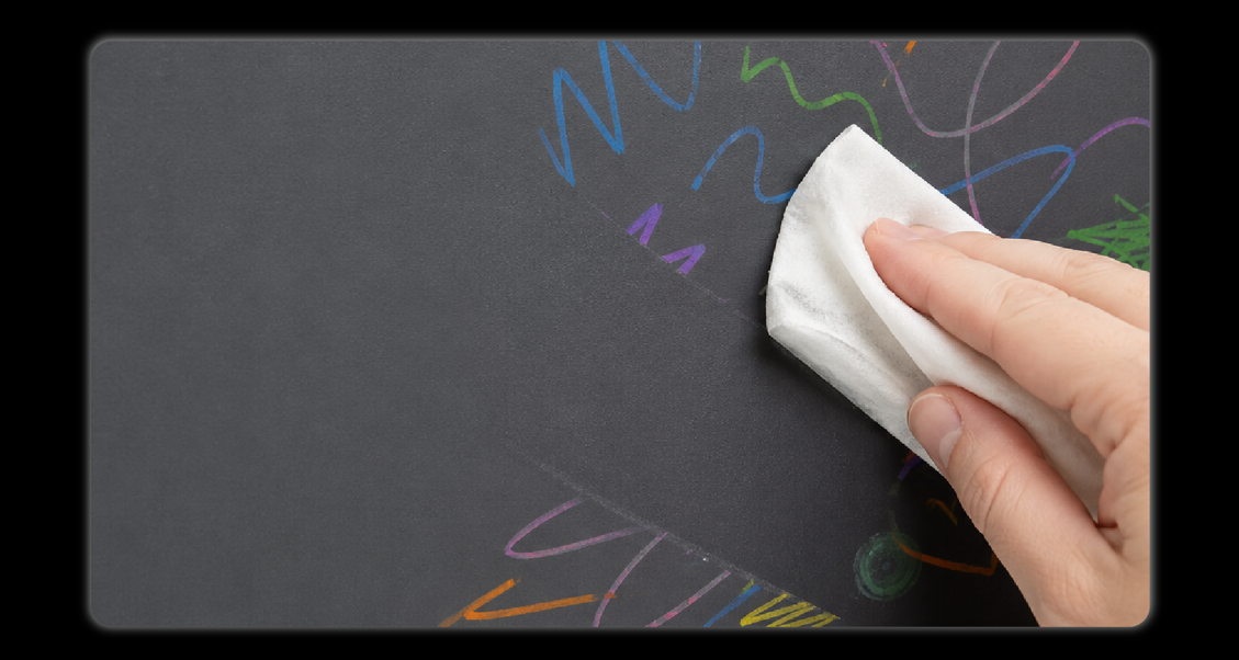 Hand wiping colorful marker drawings off stain-resistant leather interior with white cloth