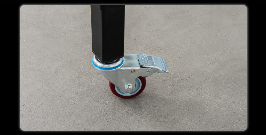 Close-up of caster wheel with red tire and silver bracket mounted on black support leg