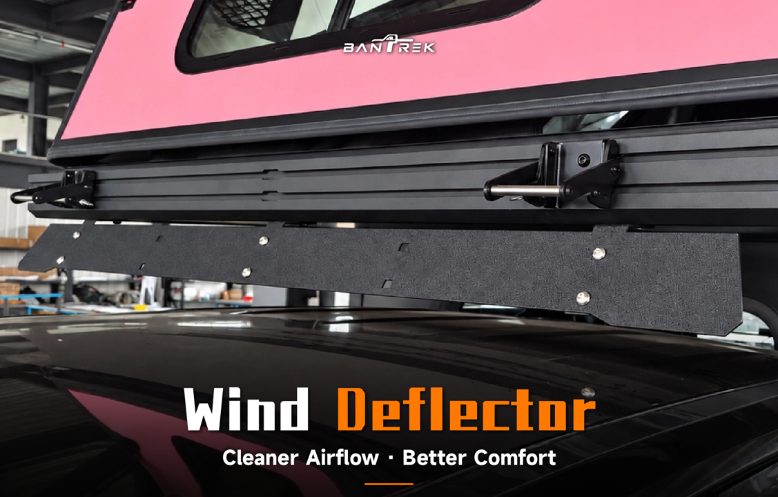 BANTREK wind deflector installed under camper on black truck roof showing stainless steel plate and mounting brackets